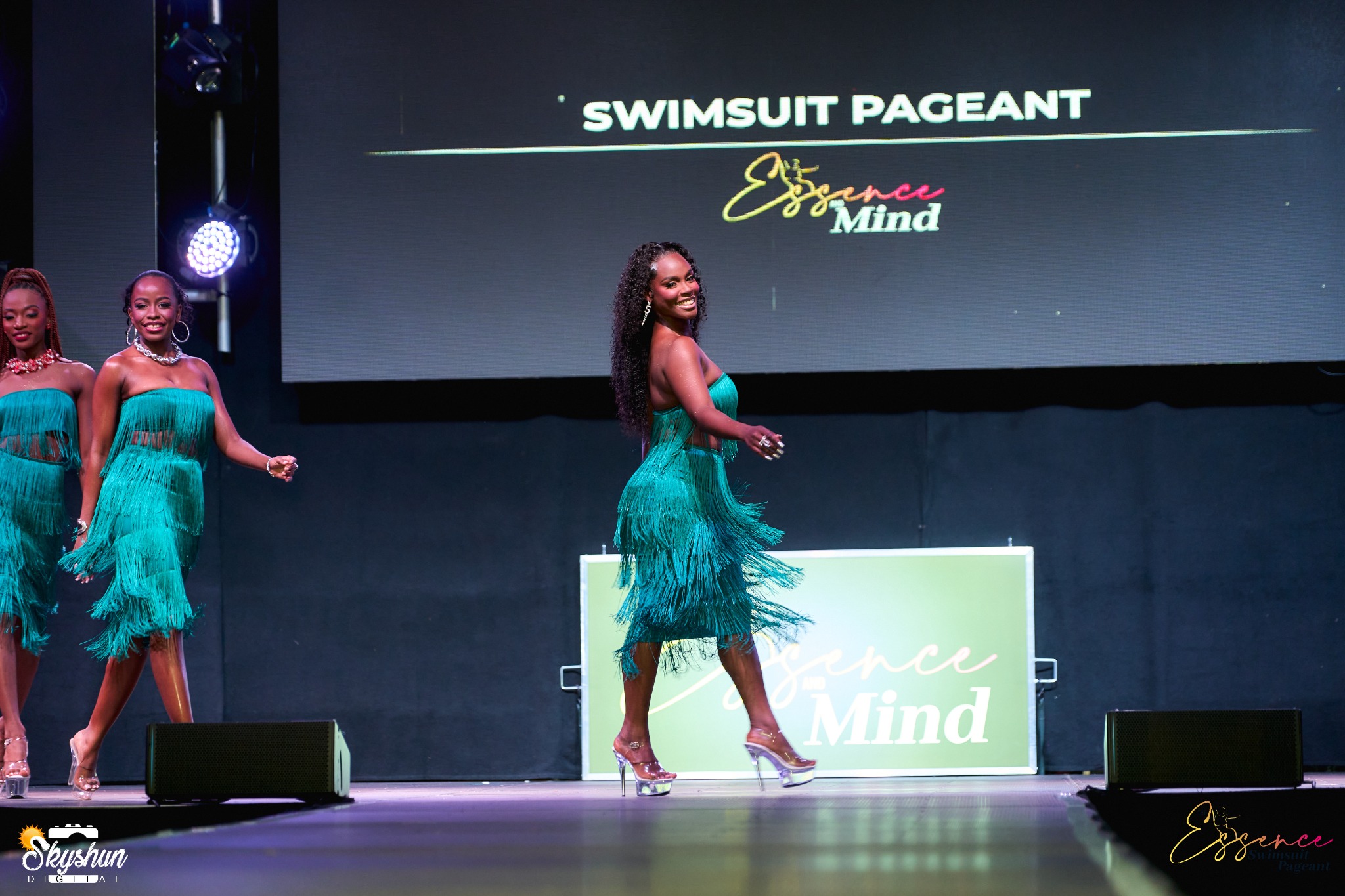 Contestants performing in coordinated teal outfits